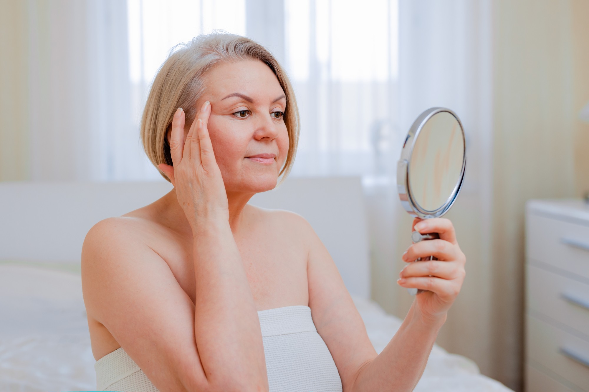 portrait pretty senior woman with hands on her face mirror at home after bathroom Skin care after 50-60 years